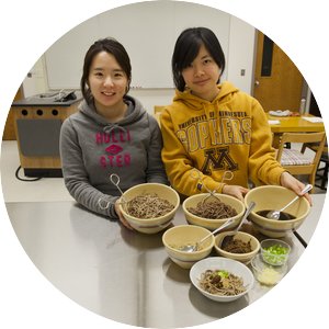 two students with noodle dishes