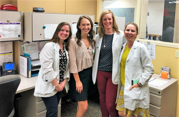 preceptors and interns in hospital office wearing lab coats